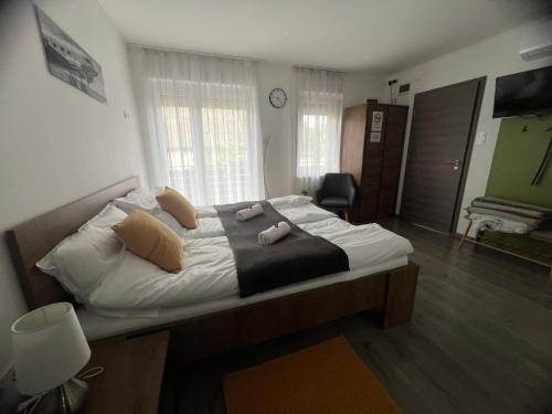 a bedroom with a bed with white sheets and pillows at Sophia Apartman Gödöllő in Gödöllő