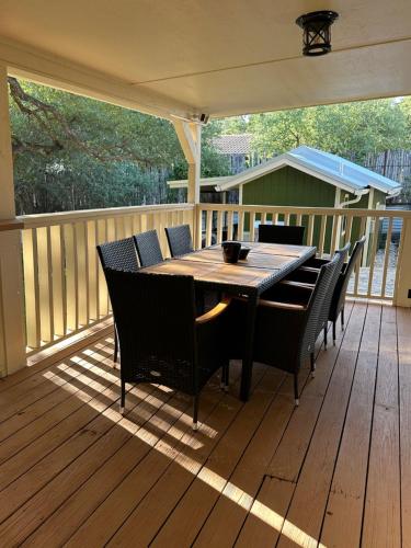 a wooden deck with a table and chairs on it at Sanctuary on the Frio in Concan