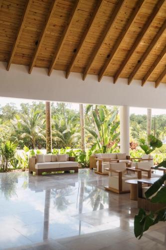 a lobby with couches and tables and palm trees at Viva Miches by Wyndham, a Trademark All Inclusive Resort in Miches