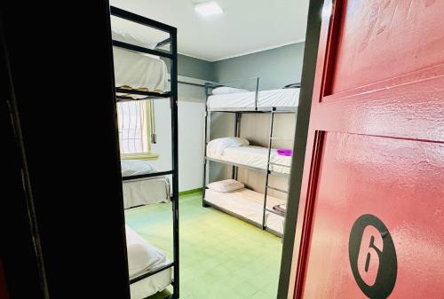 a room with bunk beds and a red door at Lacandona Hostel in Cordoba