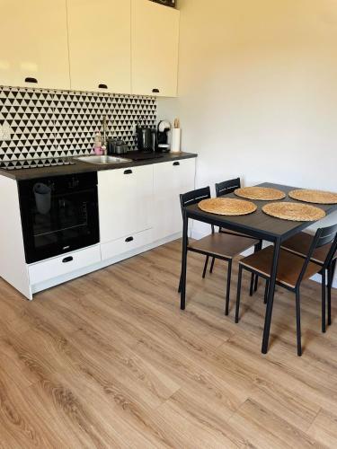 a kitchen with a table and chairs and a microwave at Domek nad Drawskim in Stare Drawsko