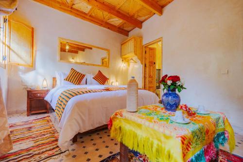 a bedroom with a bed and a table with a vase at Riad Berber Towers in Imlil