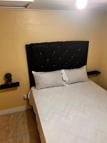 a bed with a black headboard in a room at Luxury Struan Castle Hill condo in Kupuis
