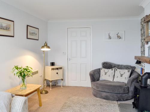 un salon avec une chaise et une table dans l'établissement Cotters Cottage - Uk10922, à Whithorn