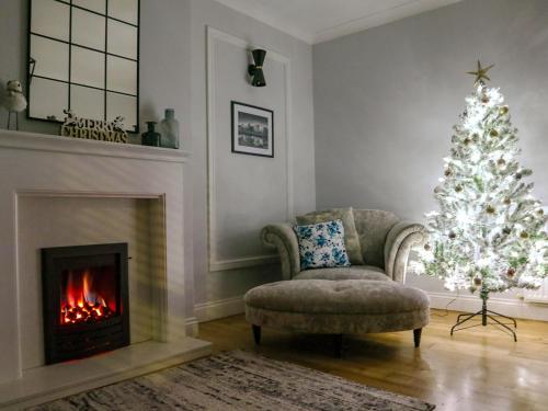 a living room with a christmas tree and a fireplace at Jubilee House in Alnwick