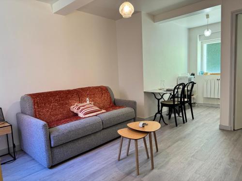 a living room with a couch and a table at Studio cosy & pratique avec parking privé in Égletons