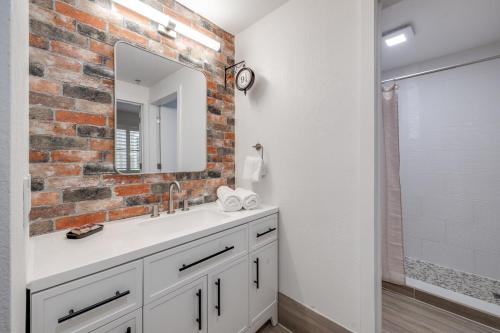 a bathroom with a white sink and a brick wall at Harry Potter Suite near Epic & Universal in Orlando