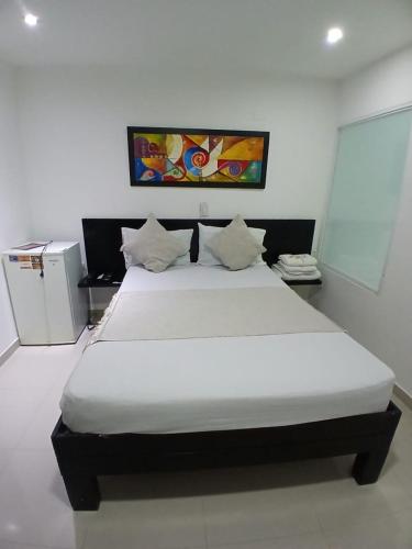 a bedroom with a large white bed in a room at Hotel Plaza Norte Cali in Cali
