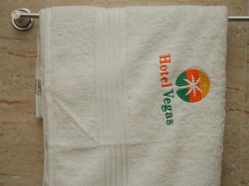 a white towel with an orange on it at Hotel Vegas in Mama