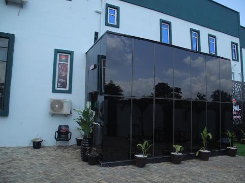 a large glass building with potted plants in front of it at Hotel Vegas in Mama