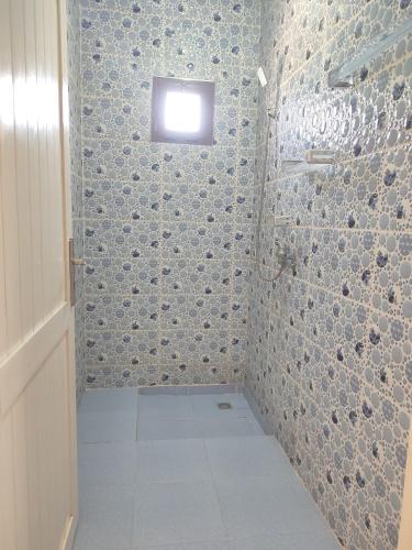 a bathroom with a shower with a small window at kaouki beachside apertmment - 4 peoples in Essaouira
