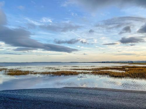 a view of a body of water with a cloudy sky at Lower Bamburgh View in Holy Island