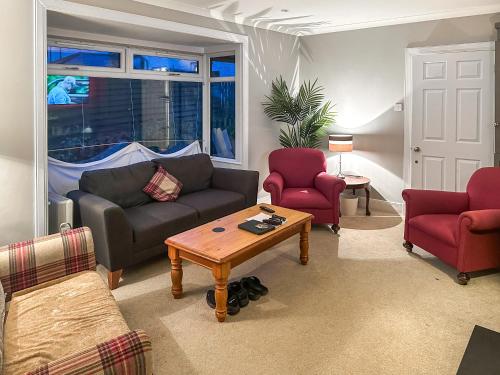 a living room with a couch and two chairs and a table at Glen Mhor in Glenelg