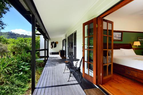 um quarto com uma cama num deque de madeira em The Laurels B&B em Kangaroo Valley