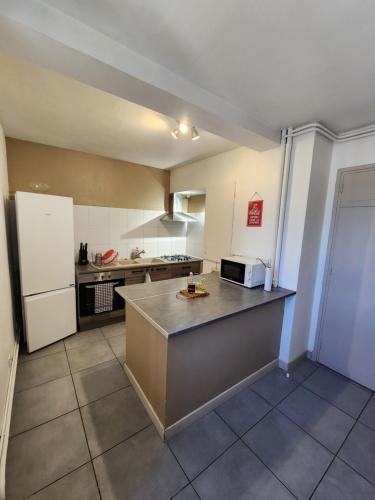 Il dispose d'une grande cuisine avec un comptoir et un réfrigérateur. dans l'établissement Grand appartement vue sur la Cité !, à Carcassonne