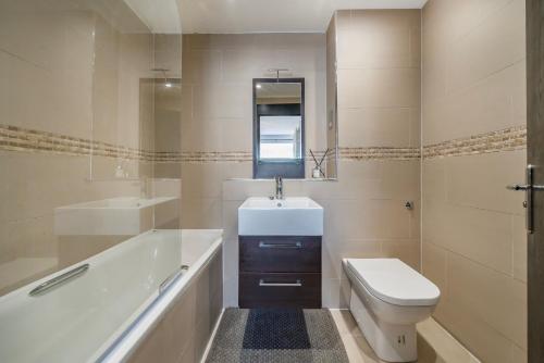 a bathroom with a sink and a toilet and a tub at ELGIN MEWS NORTH beside Maida Vale tube and parking LONG TERM BOOKINGS in London
