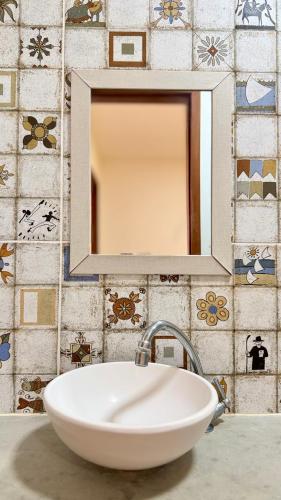 a white sink in a bathroom with a mirror at Lounge Pdd - Espaço inteiro in Aquiraz