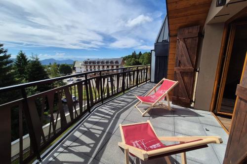 - deux chaises assises sur un balcon avec vue dans l'établissement Appartement d'Exception aux Pieds des Pistes, à La Féclaz