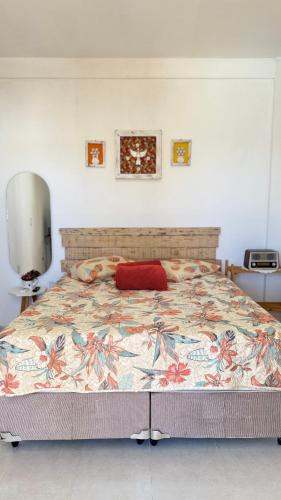 a bedroom with a large bed with a red pillow at Lounge Pdd - Espaço inteiro in Aquiraz
