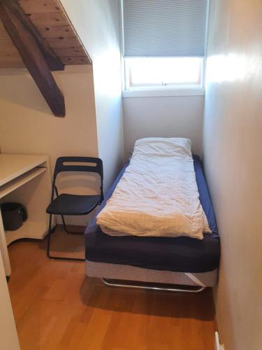 a bed in a room with a desk and a window at Oslo Stay guesthouse in Oslo