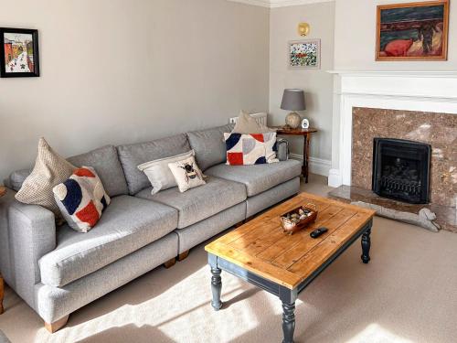 Una sala de estar con un sofá y una mesa de café. en Grey Croft, en Christon Bank