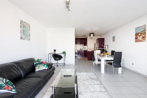 un salon avec un canapé noir et une table dans l'établissement Cannes Maria YourHostHelper, à Cannes