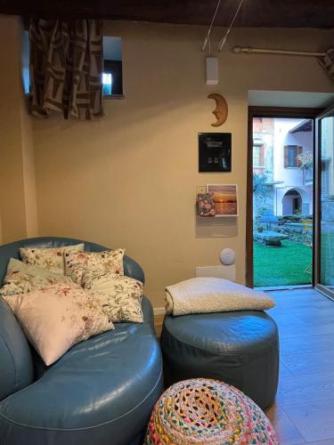 a living room with a blue leather couch and ottoman at Luna Home in Arona
