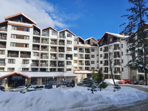 a large apartment building with snow in front of it at Borovets Gardens Forest STUDIO A3 in Borovets
