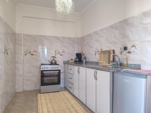 a kitchen with white cabinets and a stove at kaouki beachside apertmment - 4 peoples in Essaouira