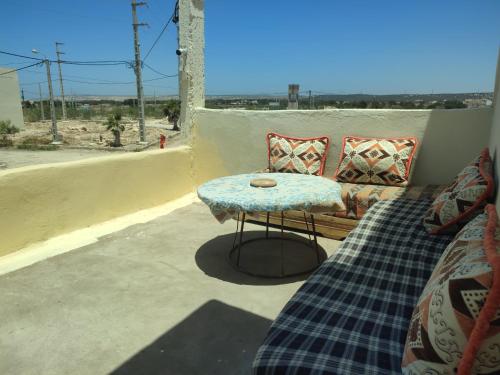 a patio with a couch and a table on a balcony at kaouki beachside apertmment - 4 peoples in Essaouira