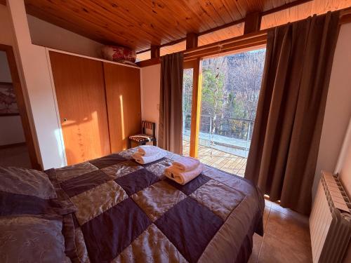 圣马丁德洛斯Duplex en el centro del pueblo con balcón terraza Ñire13的一间卧室，里面有一张床和一扇大窗户。