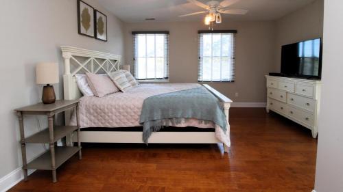 Un dormitorio con una cama, una cómoda y un televisor. en Coastal Hideaway, en West Cape May