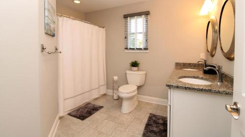 Un baño con inodoro, lavabo y ducha. en Coastal Hideaway, en West Cape May