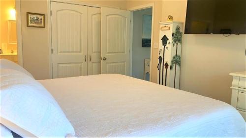 a bedroom with a white bed and a refrigerator at Seamans Folly in Cape May