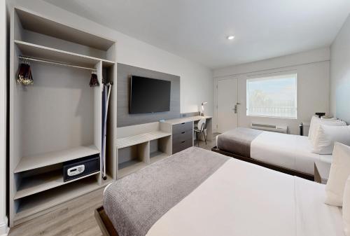 a hotel room with two beds and a flat screen tv at Avanti International Resort in Orlando