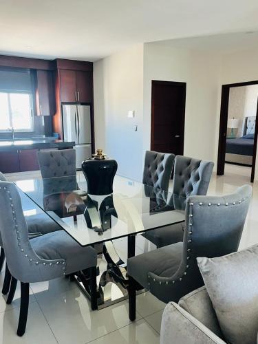 a dining room with a glass table and chairs at QC Departamento privado de lujo en Quintas in Culiacán