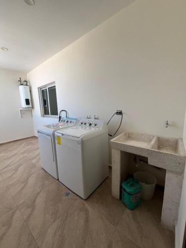 a laundry room with a washing machine and a sink at QC Departamento privado de lujo en Quintas in Culiacán