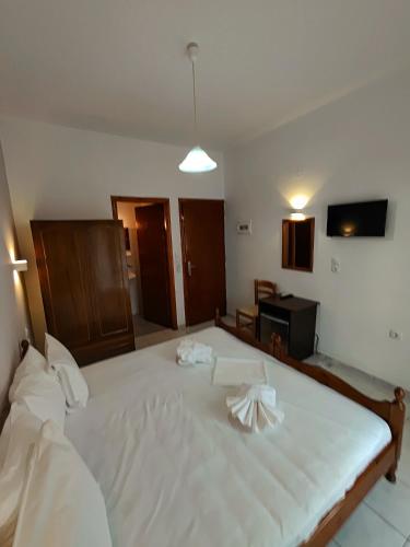 a bedroom with a large bed with white sheets at Elysian Light Apartment & Rooms in Sivota