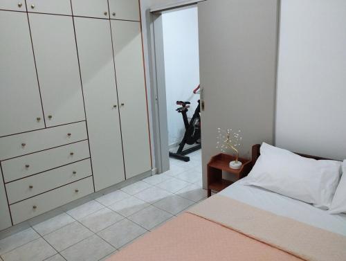 a bedroom with white cabinets and a bed and a table at Twins home in Ierápetra