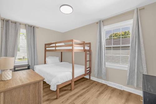 a bedroom with a bunk bed and two windows at 3BR Elam Retreat • Work & Rest in Sunset Hills