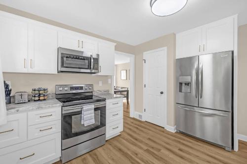 a kitchen with white cabinets and stainless steel appliances at 3BR Elam Retreat • Work & Rest in Sunset Hills