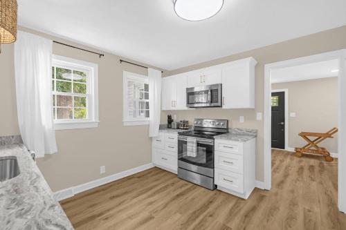 a kitchen with white cabinets and a stove at 3BR Elam Retreat • Work & Rest in Sunset Hills