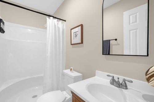 a white bathroom with a toilet and a sink at 3BR Elam Retreat • Work & Rest in Sunset Hills