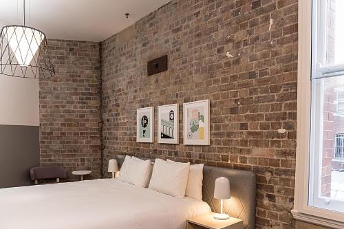 Schlafzimmer mit Ziegelwand und Bett in der Unterkunft The Ultimo in Sydney