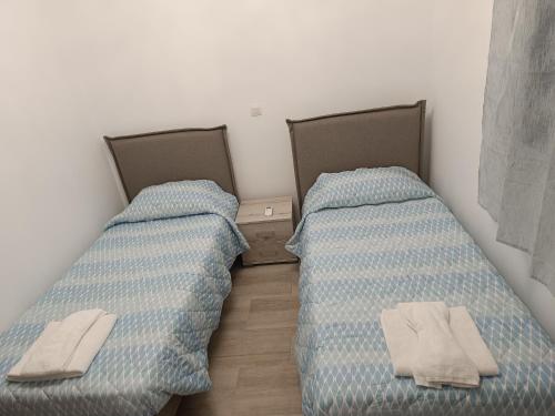 Dos camas una al lado de la otra en una habitación. en Haraki Blue Houses, en Charaki