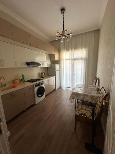 a kitchen with a table and a stove top oven at Seaside luxury apartment in Sumqayyt