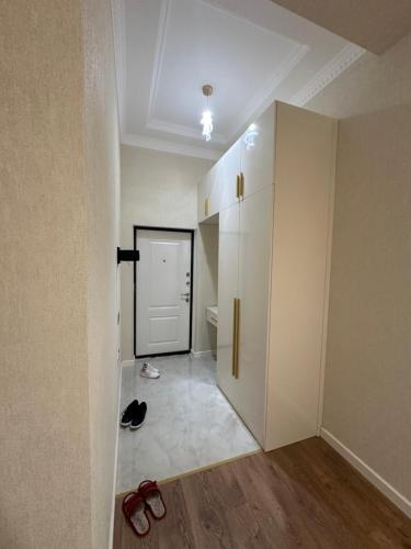 a room with a hallway with a closet and shoes on the floor at Seaside luxury apartment in Sumqayyt