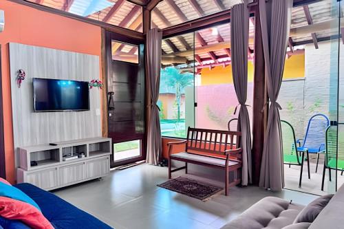 a living room with a tv and a couch at Casa no Centro de Bonito no condomínio Eco Bonito in Bonito