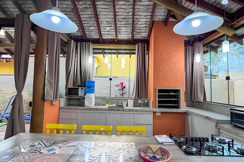 una cucina con tavolo e sedie gialle di Conforto e piscina no Centro de Bonito a Bonito