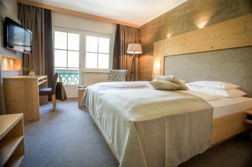 a hotel room with a large bed and a window at Hotel Annelies in Ramsau am Dachstein
